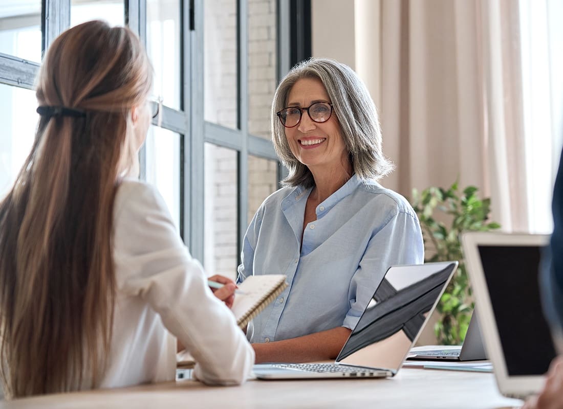Contact - Two Professionals Having a Chat in an Office