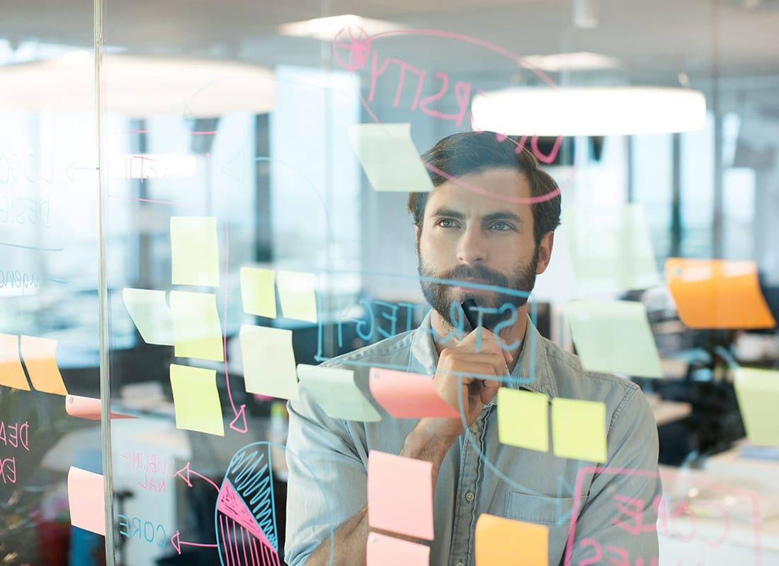 Insurance Solutions - Focused Man Looking at a Planning Board