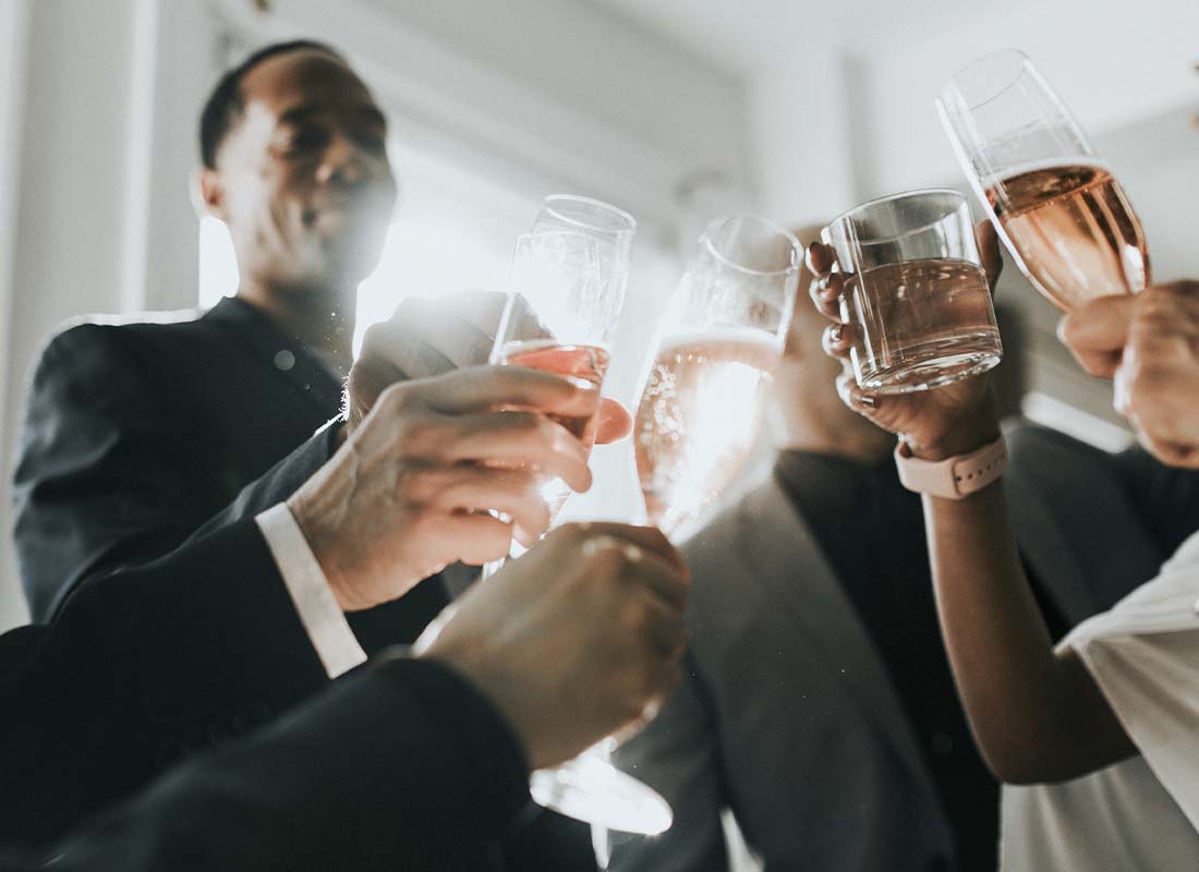 Fraternal Organization Insurance - Fraternal Organization Celebrating With Champagne in a Circle to Mark a Milestone While Clinking Glasses