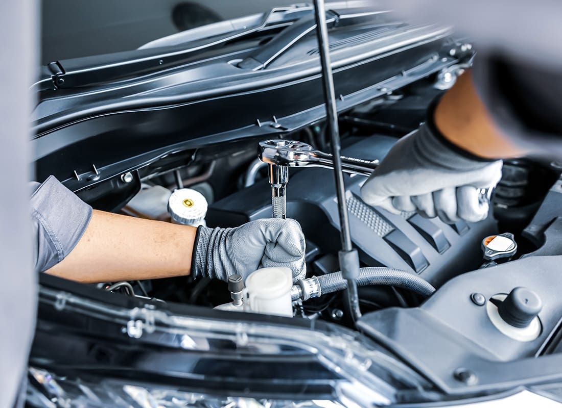 Business Insurance - Close-up of an Auto Tech Working on a Car
