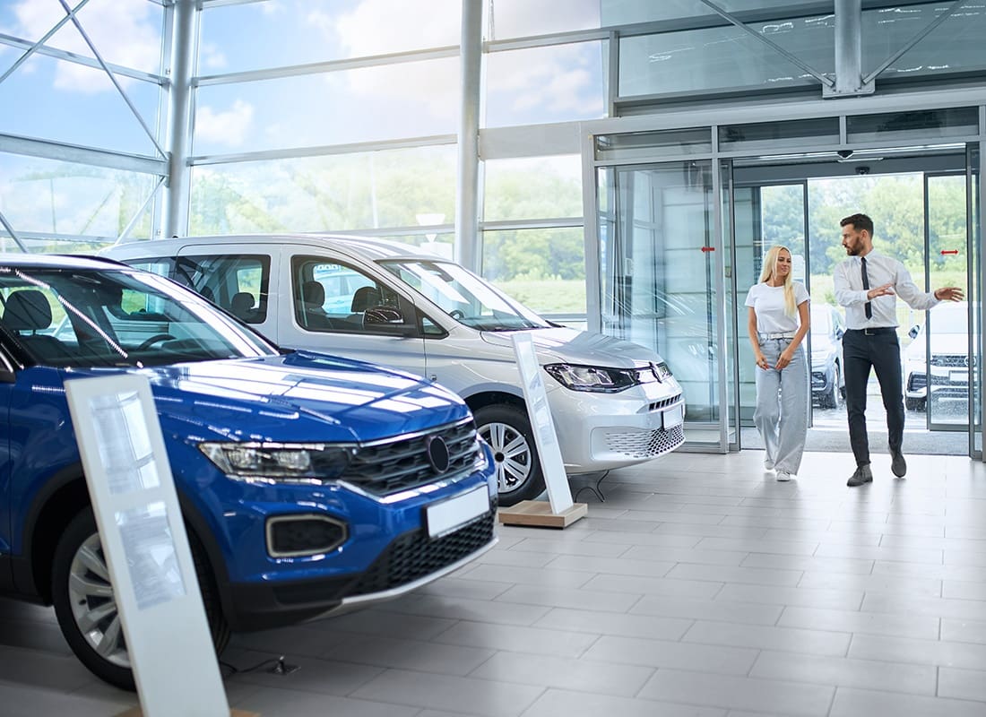 Insurance by Industry - Dealer Walking With a Woman at a Dealership